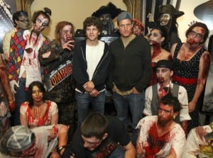 Jesse Eisenberg (center left) and co-star Woody Harrelson (center right) pose for a photo with zombies before a screening of Zombieland at AMC Loews Boston Common Theater in Boston.