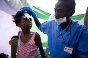 A volunteer tending to a child's injuries.