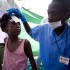 A volunteer tending to a child's injuries. A volunteer tending to a child's injuries.
