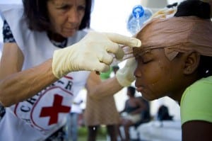 A volunteer cleaning a child's wounds