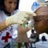 A volunteer cleaning a child's wounds A volunteer cleaning a child's wounds