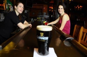 The bartender can't help but be interested in the Guinness. After all, she poured it. (Blast staff photo/Steve Osemwenkhae)