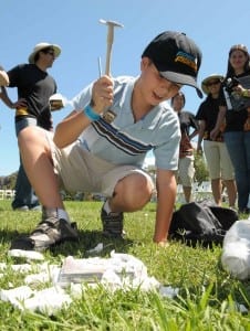 Eric S., 8, of Miami, Florida breaks open a "fossilized' copy of Fossil Fighters for the Nintendo DS and Nintendo DSi portable games systems at the La Brea Tar Pits, Thursday, August 6, 2009 in Los Angeles. Eric won a game play tournament at the event to celebrate the game's upcoming release on August 10, 2009.    (Photo by Nintendo, Bob Riha, Jr.) 