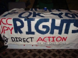 This freshly-painted banner, shown here the night before the arrests, was carried by one of the protestors. (Blast Staff photo/John Stephen Dwyer)