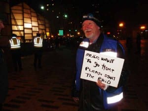 With tense anticipation in the air, Bill the Medic lightened the mood of both police and protestors with a hand-made sign (Blast Staff photo/John Stephen Dwyer)